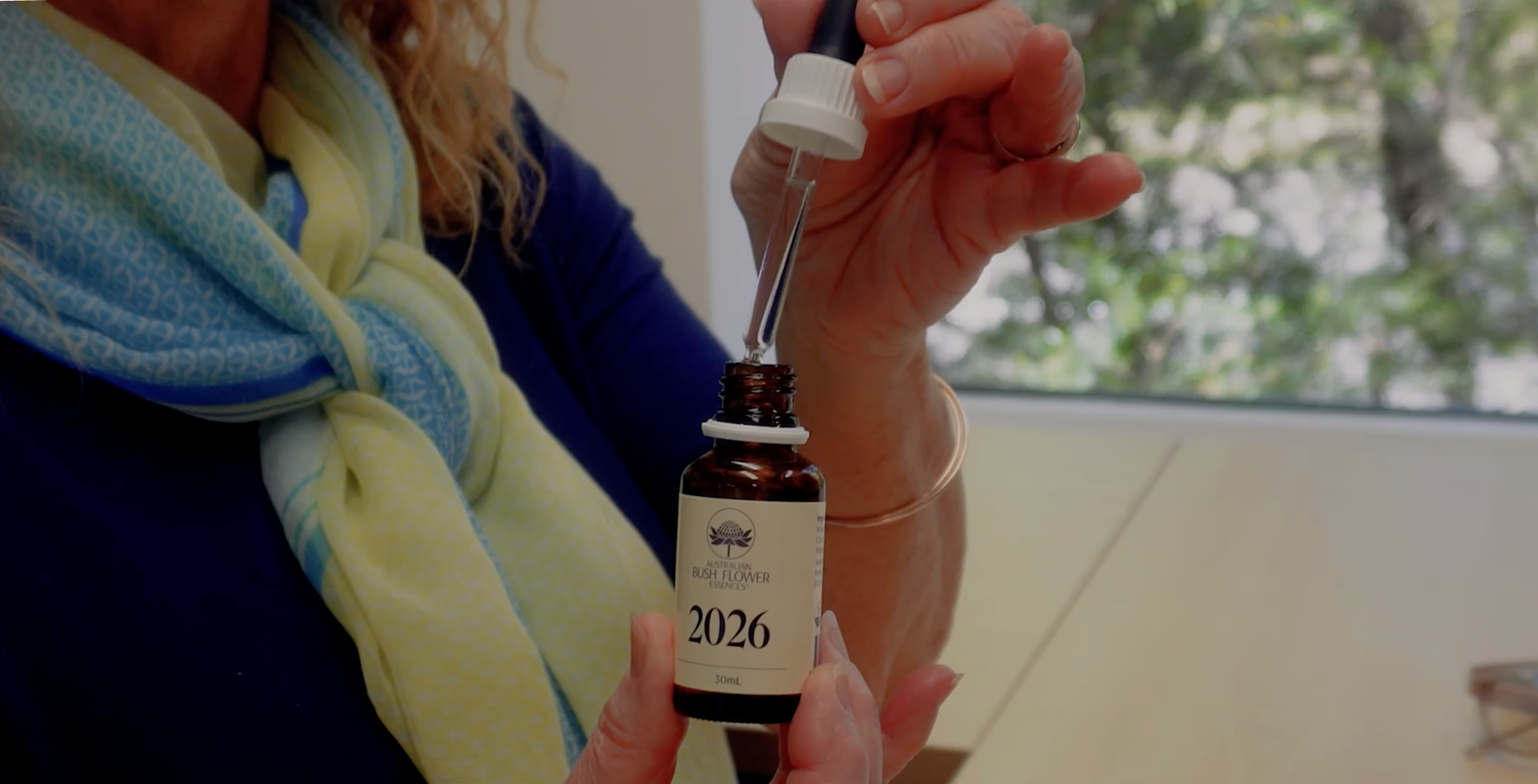 Nahaufnahme einer Person, die mit einer Pipette ein braunes Fläschchen Australian Bush Flower Essences 2026 hält.